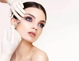 A medical professional with gloved hands gives a woman an injection near her eye for an aesthetic treatment.